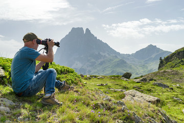 Hiker with camera taking picture of beautiful mountain