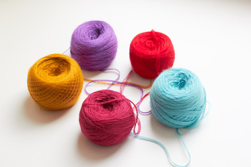 The balls of bright colored threads on the table