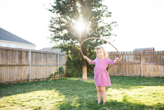 Young girl playing with hula hoop