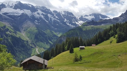 Fototapeta na wymiar Wooden cabins on steep hills in the beautiful Swiss Alps