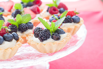 Mini tarts on the plate close up. Homemade dessert with delicious catalonian traditional cream and fresh berries