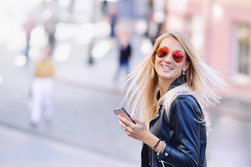 Obraz premium Young smiling woman with shopping bags and smartphone.