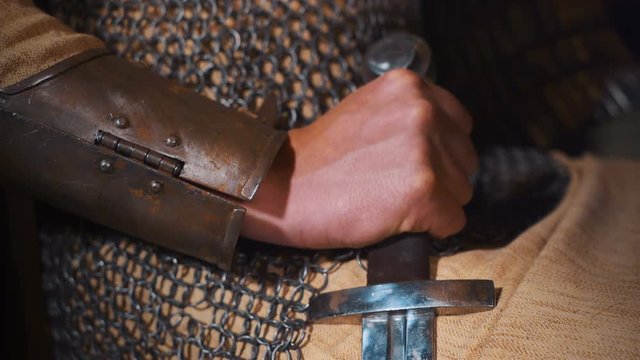 Close up of man in medieval armor gripping his sword by the hilt. Shot with Sony a7s and Atomos Ninja Flame