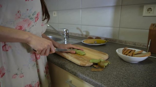 Brunette girl makes fruit slices
