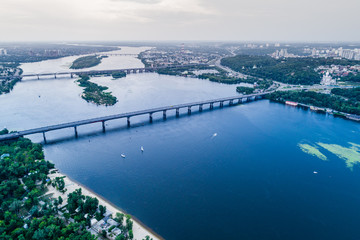 Panoramic view of Kiev city with the Dnieper River in the middle. Aerial view of the residential district and industrial Zone at sunset. Two banks of the river connected by bridges