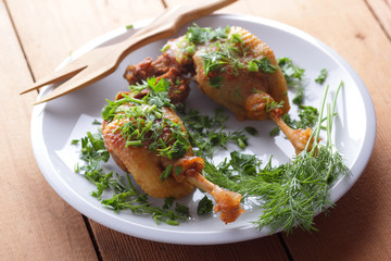 Fried duck leg on a white plate sprinkled with herbs for a restaurant