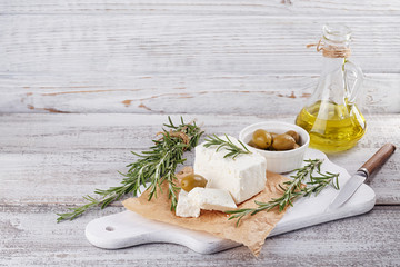 Fresh feta cheese with rosemary on white wooden serving board