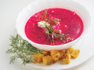 borsch soup red with greens on a white plate