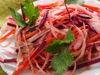 beets salad with greens on a white plate