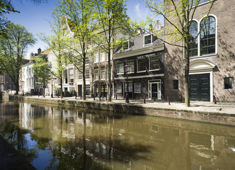 Traditional dutch buildings, trees and their reflections in canal's water, Amsterdam, Netherlands