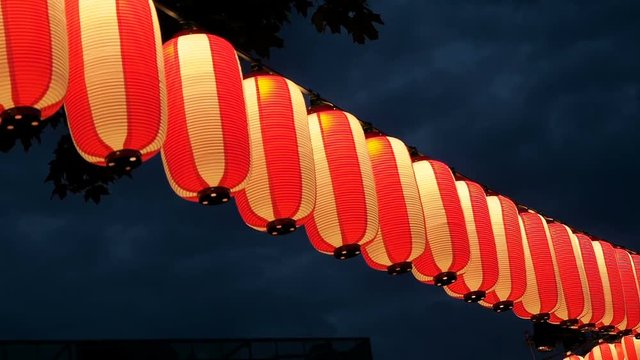 Paper red-white japanese lanterns Chochin shines on dark sky