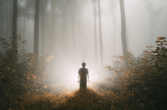 Man with strange magical light in autumn forest