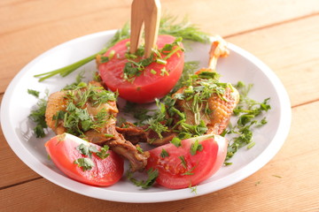 Roasted duck legs with tomato and herbs with wooden cutlery