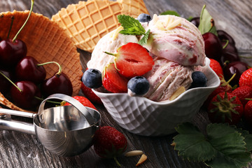 Strawberry ice cream in white bowl with fresh strawberries and blueberries