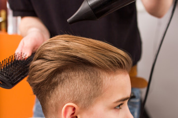 little boy getting haircut by barber