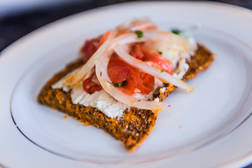 Macro closeup of healthy onion appetizer on chia flatbread toast and cheese