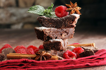 homemade chocolate brownies with raspberries and mint on wooden background