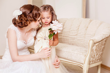 Shy flower girl gives a flower to bride. Wedding. Just married. Kids at the wedding. Wedding hairstyle