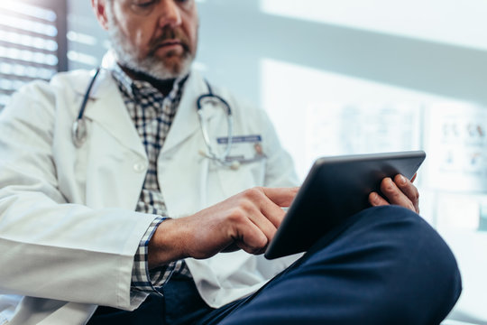 Doctor using digital tablet in his office