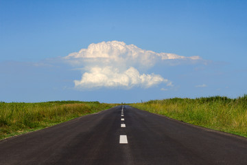 straight road with white cloud at the horizon