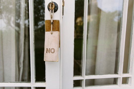A sign saying No hanging on a door.