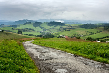 Fototapeta na wymiar Summertime rural landscape - view at road to the village Pucov, Zilina Region in the Slovakia