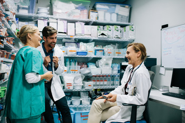 Hospital staff having casual discussion in the pharmacy - obrazy, fototapety, plakaty