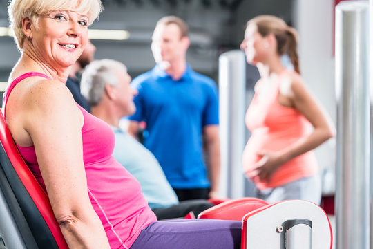 senior woman in group with pregnant woman working out at the gym for better fitness