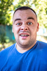 Fototapeta premium Young man in a blue T-shirt with a chipped tooth