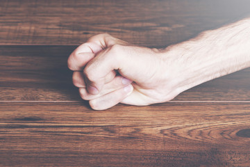 Closeup on a man slamming his fist on a wooden table