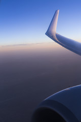 view from window seat during flight. Blue sky at sunrise. Wing. Airplane