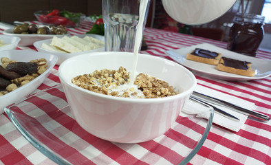 Pouing milk on cereal in the morning