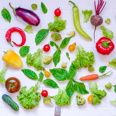 Collection of fresh organic vegetables and greeens on white wooden table. Top view. Healthy foods, cooking and vegetarian concept background. Selective focus, square format