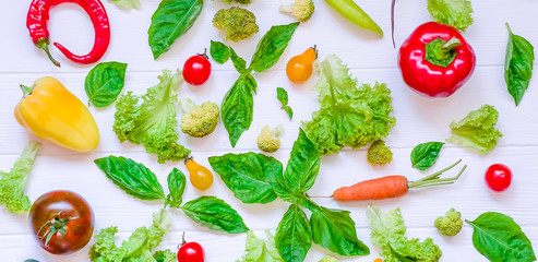 Collection of fresh organic vegetables and greeens on white wooden table. Top view. Healthy foods, cooking and vegetarian concept background. Selective focus, wide photo