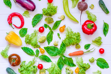 Collection of fresh organic vegetables and greeens on white wooden table. Top view. Healthy foods, cooking and vegetarian concept background. Selective focus