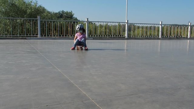 Little girl on skateboard. A child skates sitting on a skateboard.