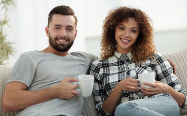 Close-up of a loving couple sitting on a sofa in the living room