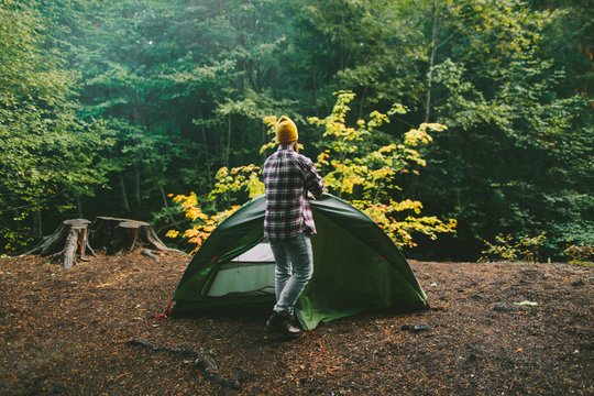 Man Wearing Flannel and Yellow Beanie Setting Up Tent At Campsit
