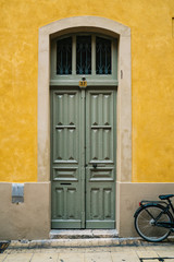 Fototapeta na wymiar Green doors with yellow wall in France