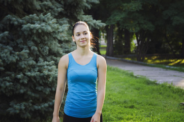 The girl is engaged in sports running in the park. Training on the street in the summer morning. Concept sport healthy lifestyle.