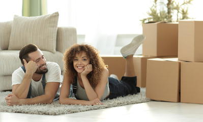 concept of moving to a new home. Happy couple lying on the floor