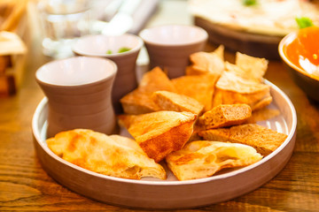 Pieces of different bread and sauces are on the plate.
