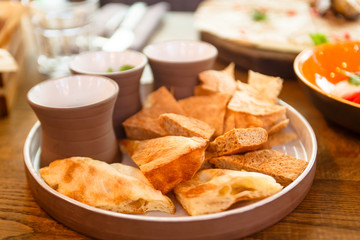 Pieces of different bread and sauces are on the plate.