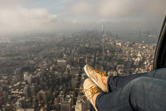 A woman's Feet Dangle Outside of a Helicopter as it Flies Over Manhattan.