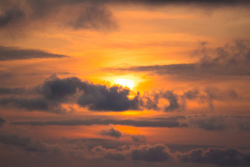 Fototapeta na wymiar Orange sunset behind the clouds
