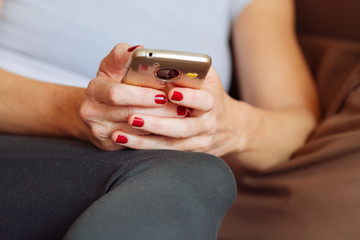 Woman reclining on a sofa using a smartphone