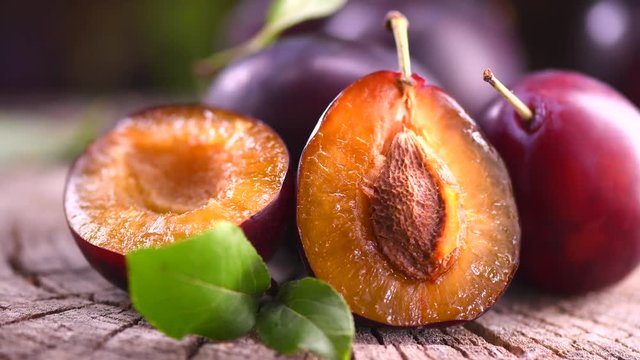 Plum. Ripe organic plums closeup on wooden table. 4K UHD video footage. Ultra high definition 3840X2160