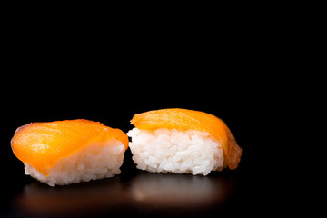 Sushi, japanese food, rice with salmon on black background.