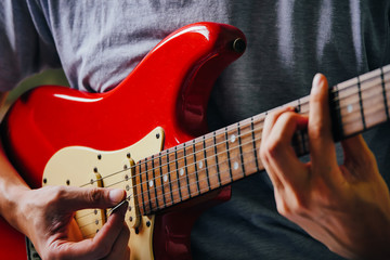 Close up of male hands playing electric guitar. Selective focus - obrazy, fototapety, plakaty