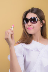 Obraz premium Beautiful woman using a lipstick